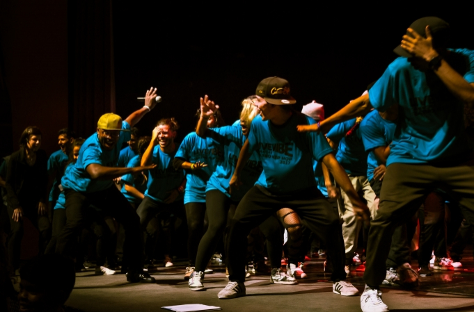 Hakeem Onibudo dances in front of a crew of hip hop artists from Venezuela