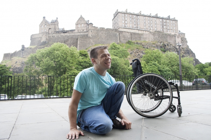 Image of artist Robert Softley on ground next to wheelchair photo: Niall Walker