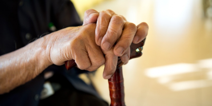 Image of hands holding on to wooding cane. Photo. DISABILITY BENEFITS 